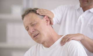Um homem com osteocondrose do pescoço em uma consulta com um massagista manual